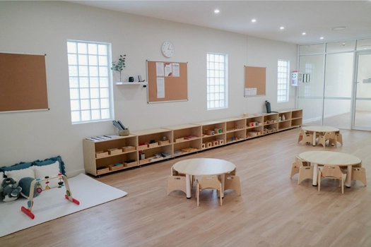 Bright Montessori classroom at Auburn West Montessori Academy with learning shelves and child-sized tables