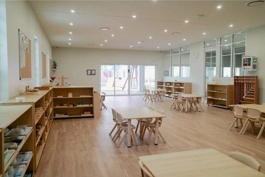 Spacious Montessori classroom at Auburn West Montessori Academy with activity tables and learning shelves