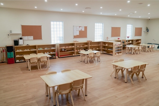 Spacious Montessori classroom at Auburn West Montessori Academy with activity tables and learning shelves