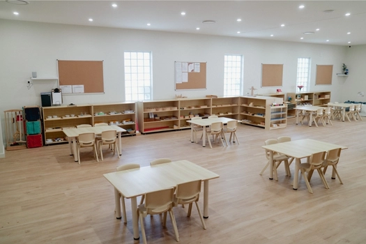 Spacious Montessori classroom at Auburn West Montessori Academy with activity tables and learning shelves