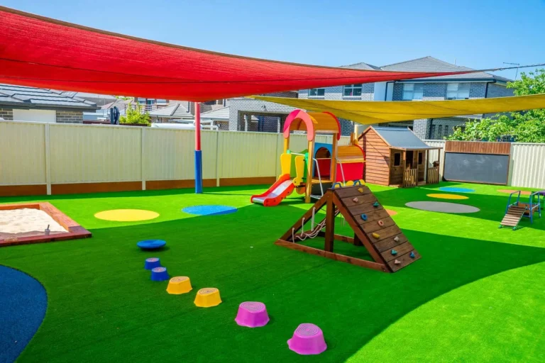 Shaded outdoor playground at Condell Park Montessori Academy with slide, climbing equipment and sandpit