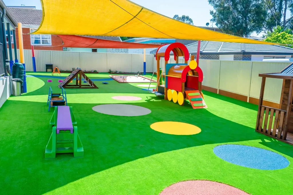 Shaded outdoor playground at Condell Park Montessori Academy with climbing equipment and open play space