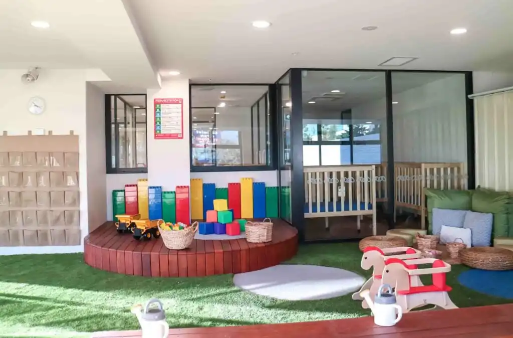 Indoor outdoor Montessori play area at Crows Nest childcare with soft flooring, building blocks, crib room and glass learning spaces
