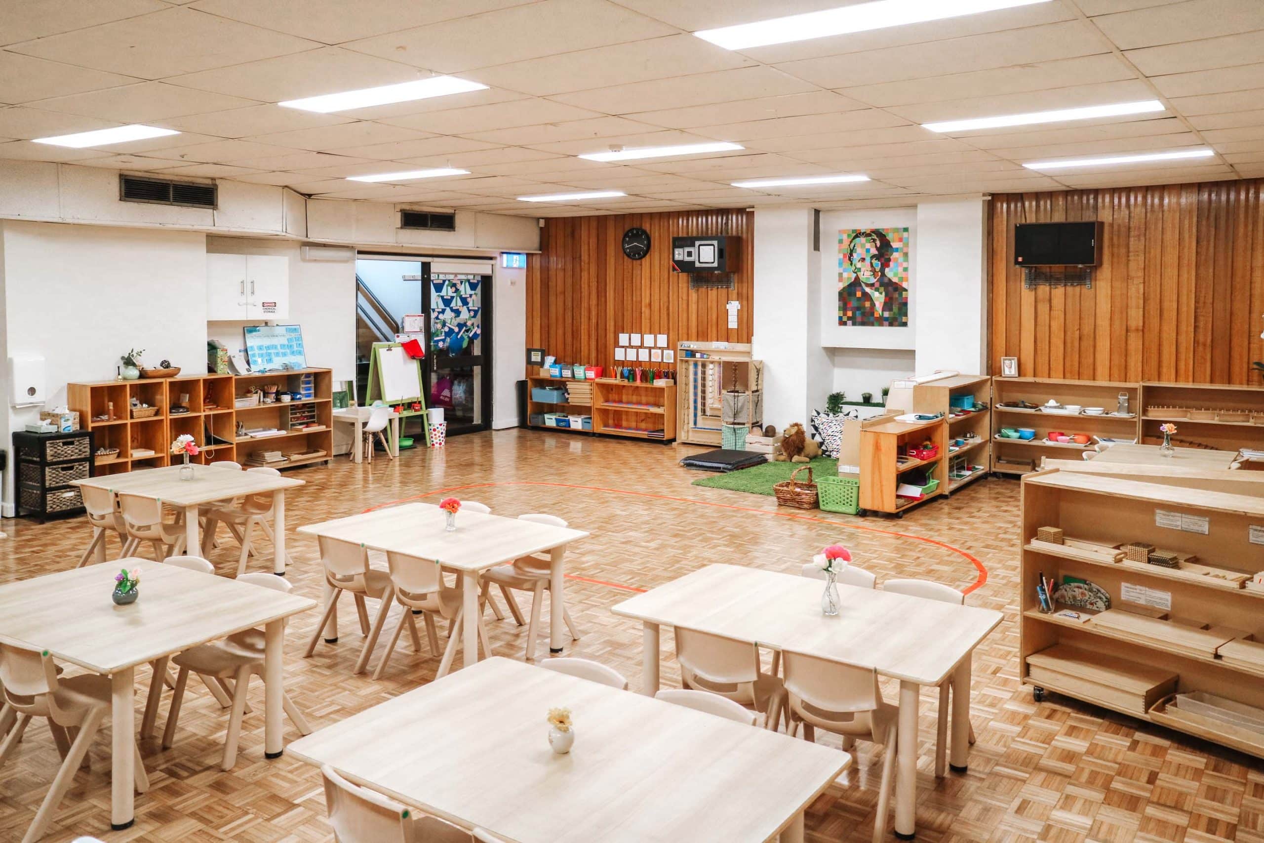 Classroom interior at Croydon Montessori Academy, with children’s tables and shelves of Montessori educational materials.