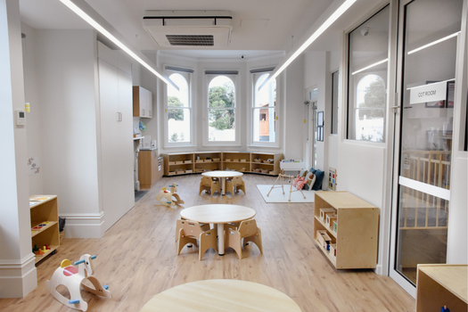 Infant classroom at Elsternwick Montessori Academy with natural timber furniture and Montessori learning materials.