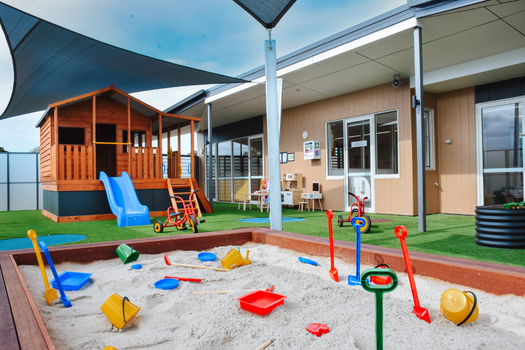 Sandpit and outdoor learning environment at Elsternwick Montessori Academy with cubby house and play equipment.
