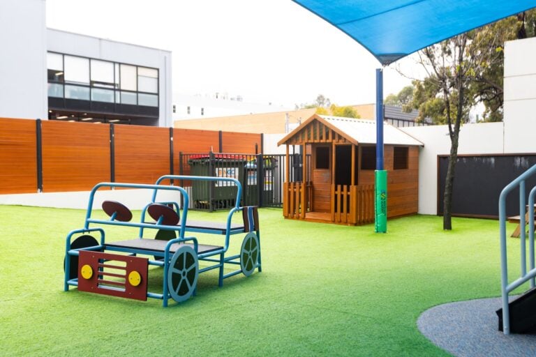 Outdoor play area at Entrada Parramatta childcare centre with cubby house and imaginative play equipment