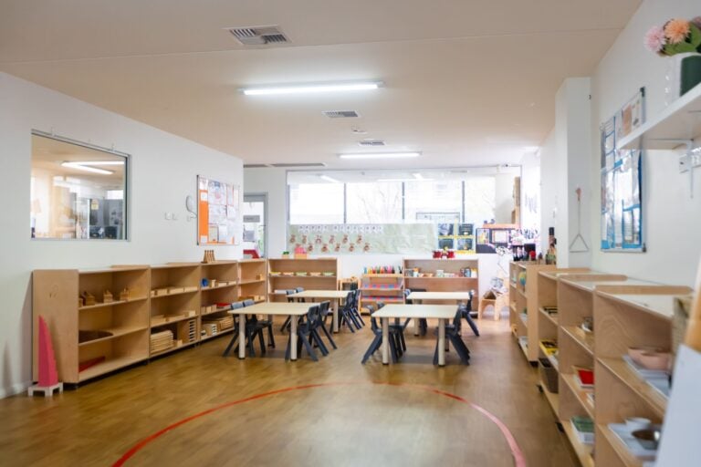 Early learning classroom at Entrada Parramatta childcare centre with activity tables and open learning shelves