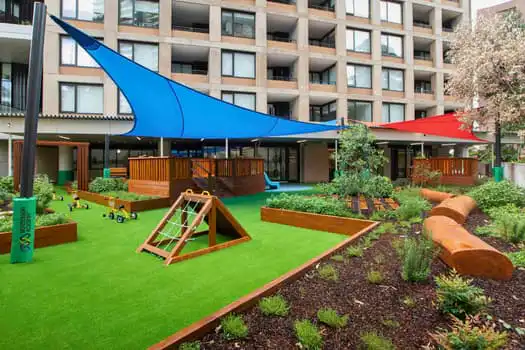 Outdoor playground at Midtown MacPark Montessori Academy childcare with gardens and climbing equipment