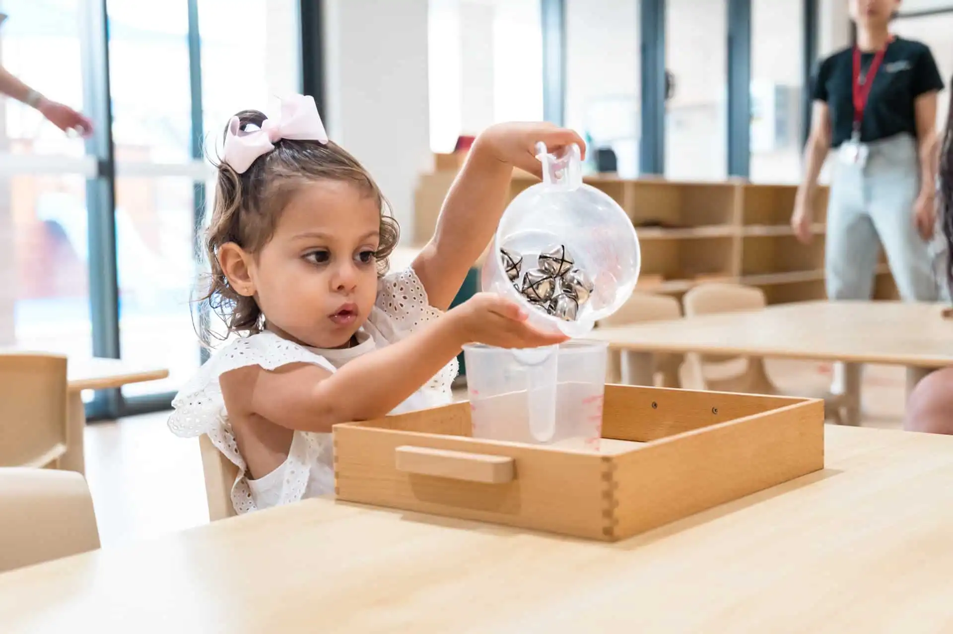 Young girl pouring from one jar into another