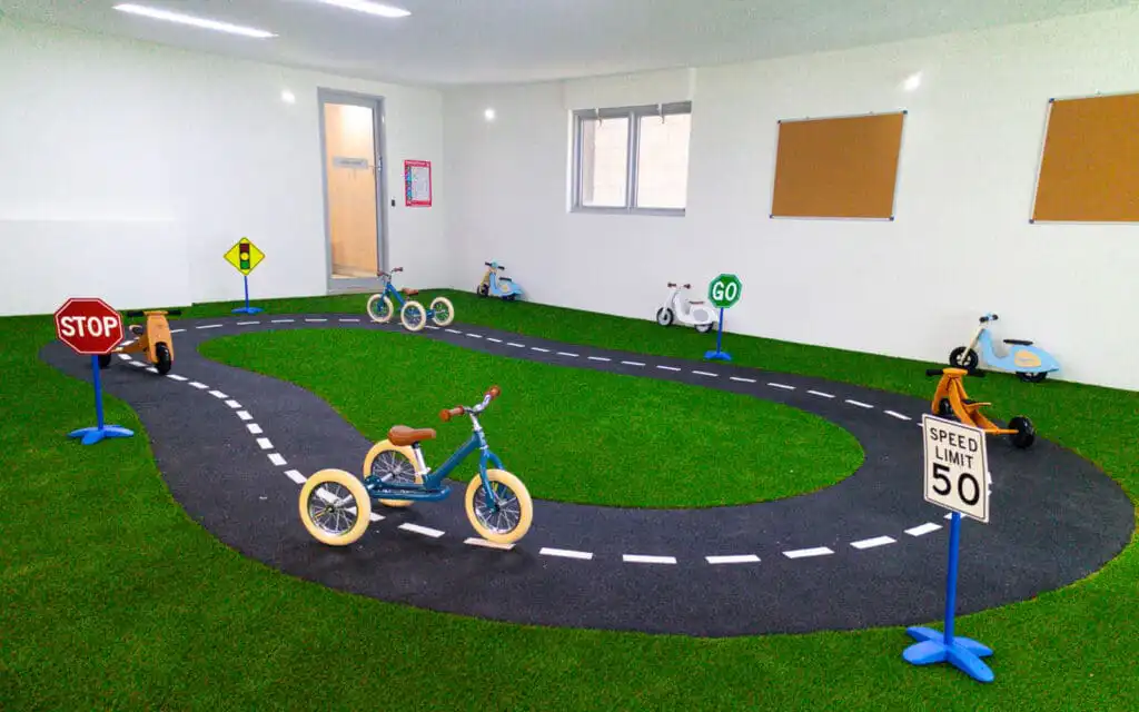 Bike track with multiples tricycles and toy stop signs and traffic lights