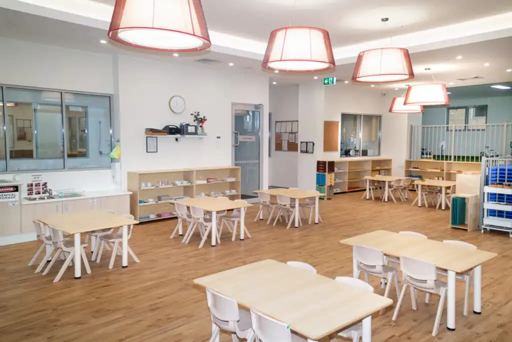 Preschool Classroom with Montessori Materials on shelves, with desks and chairs