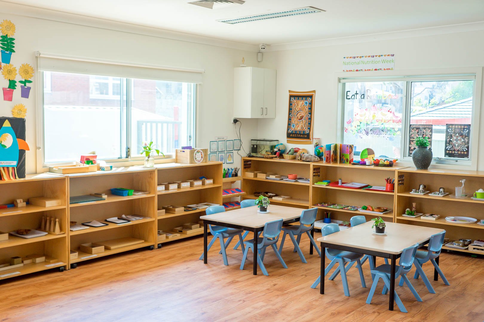 Classroom interior at Montessori Academy’s Condell Park childcare, with shelves of learning materials and children’s tables.