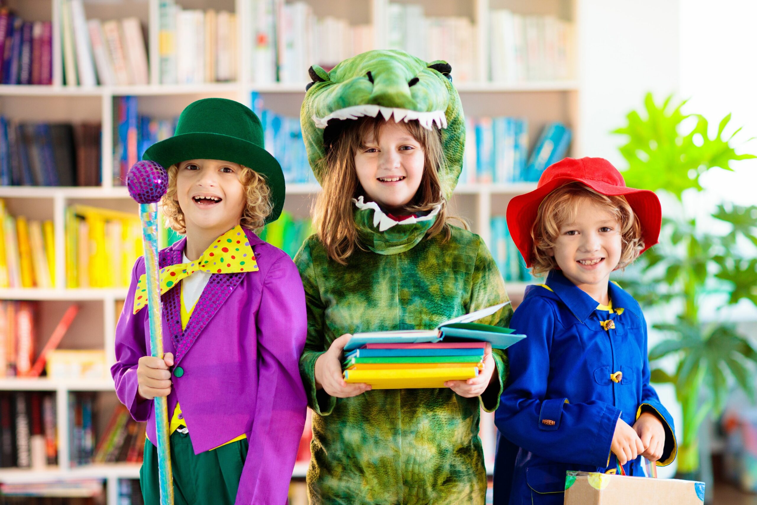 3 children standing, smiling and dressed in book character costumes