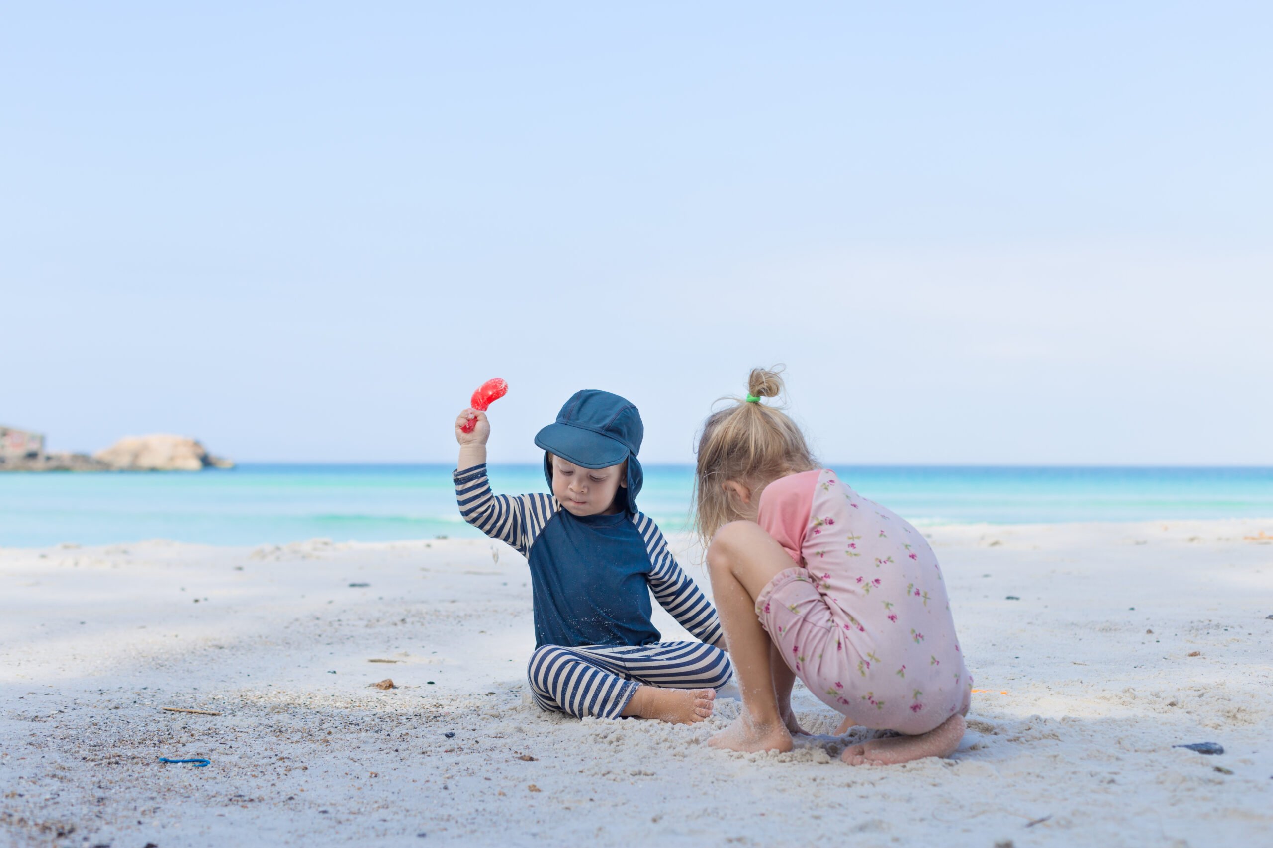 Two small children playing on the beach