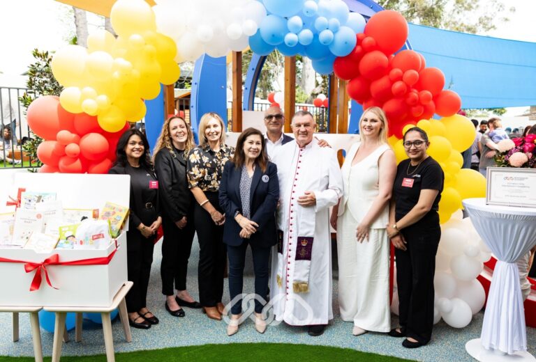 Leadership and community leaders pose for photograph in front of balloon arch at Winston Hills Montessori Academy grand opening