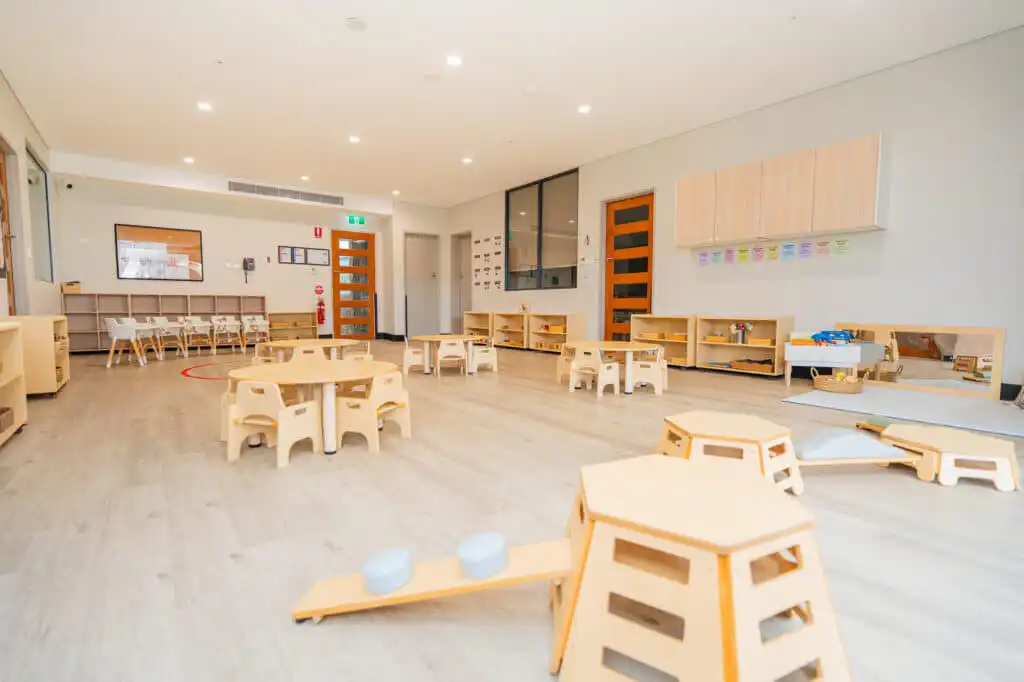 Bright Montessori classroom at Leppington childcare centre with child-sized tables and learning shelves