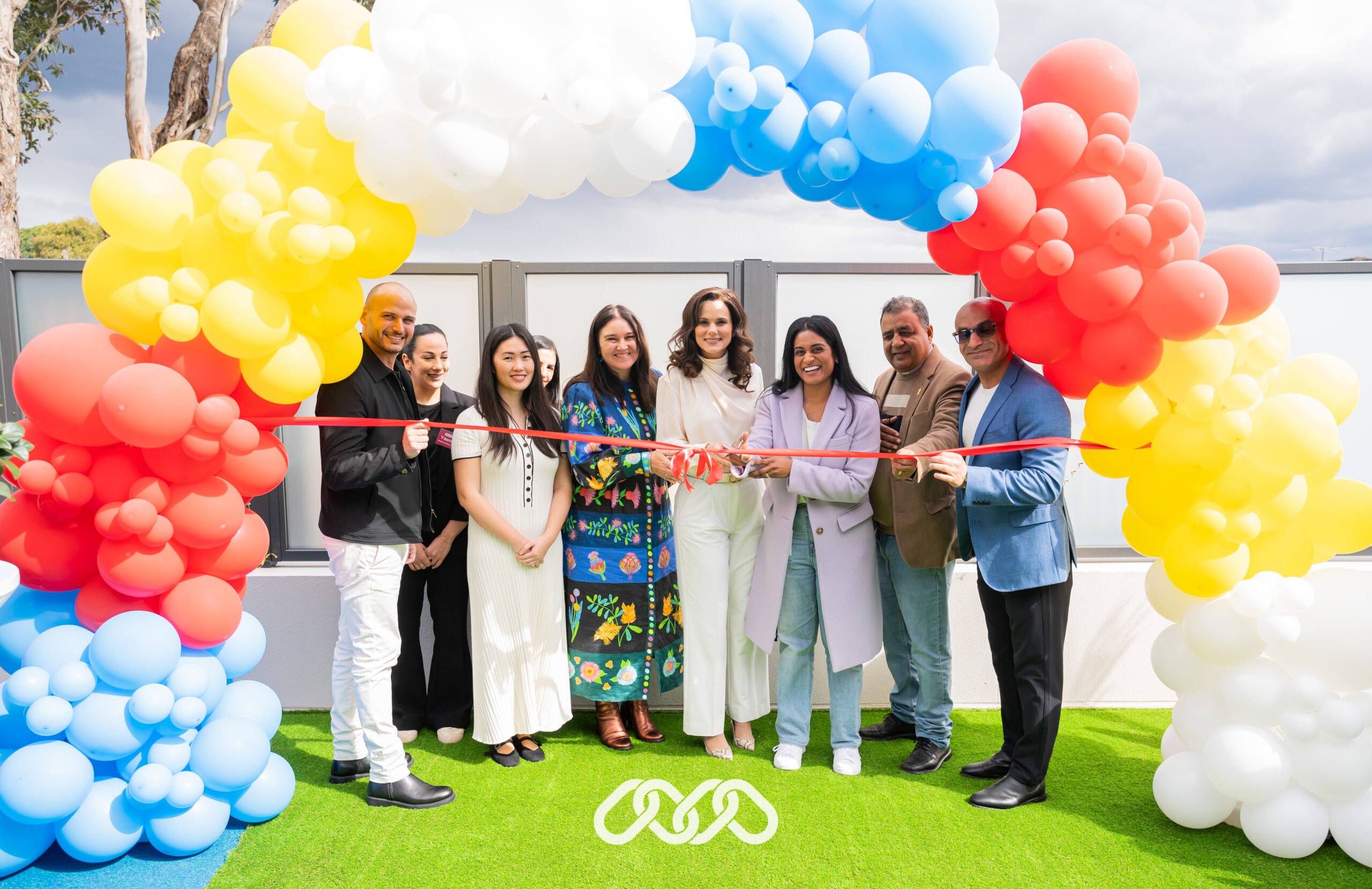 Senior community leaders stand together under balloon arch at the grand opening of a Montessori childcare centre in Bexley, NSW.