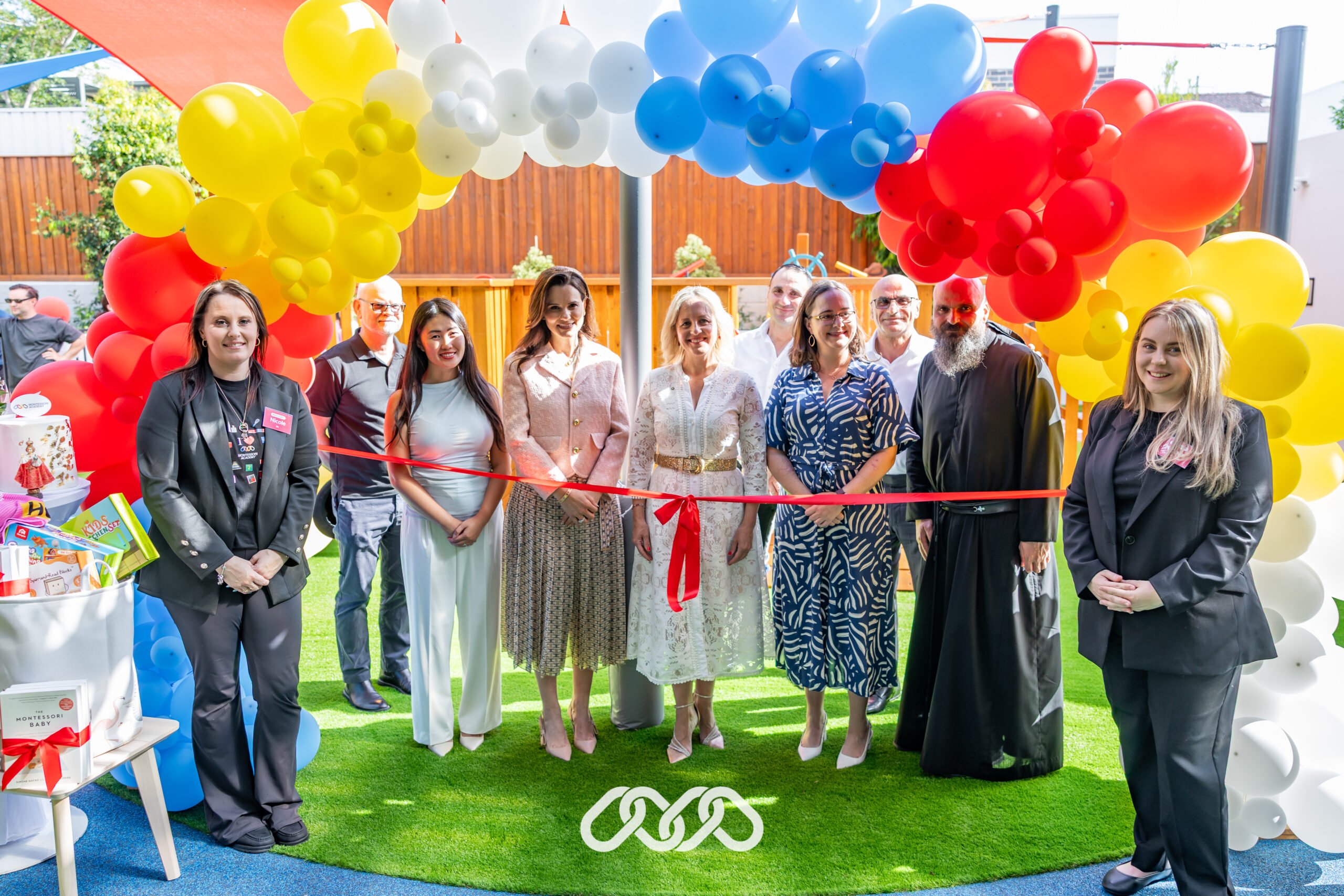 Senior leadership and community leaders gather under balloon arch at Penrith Derby Street grand opening event.