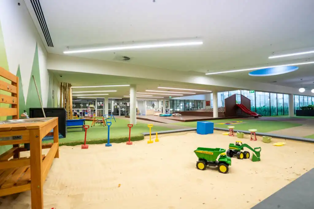 Gungahlin Childcare Outdoor Area with sandpit, bike track with tricycles, climbing frame, and slides.