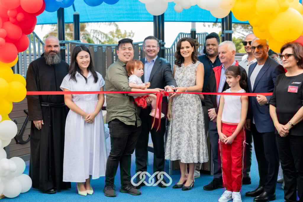 Montessori Academy leadership and local community leaders with children gather under colourful balloon arch for grand opening celebrations