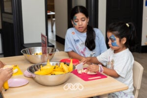 Children working with banana cutting practical life activity at Riverwood Grand Opening