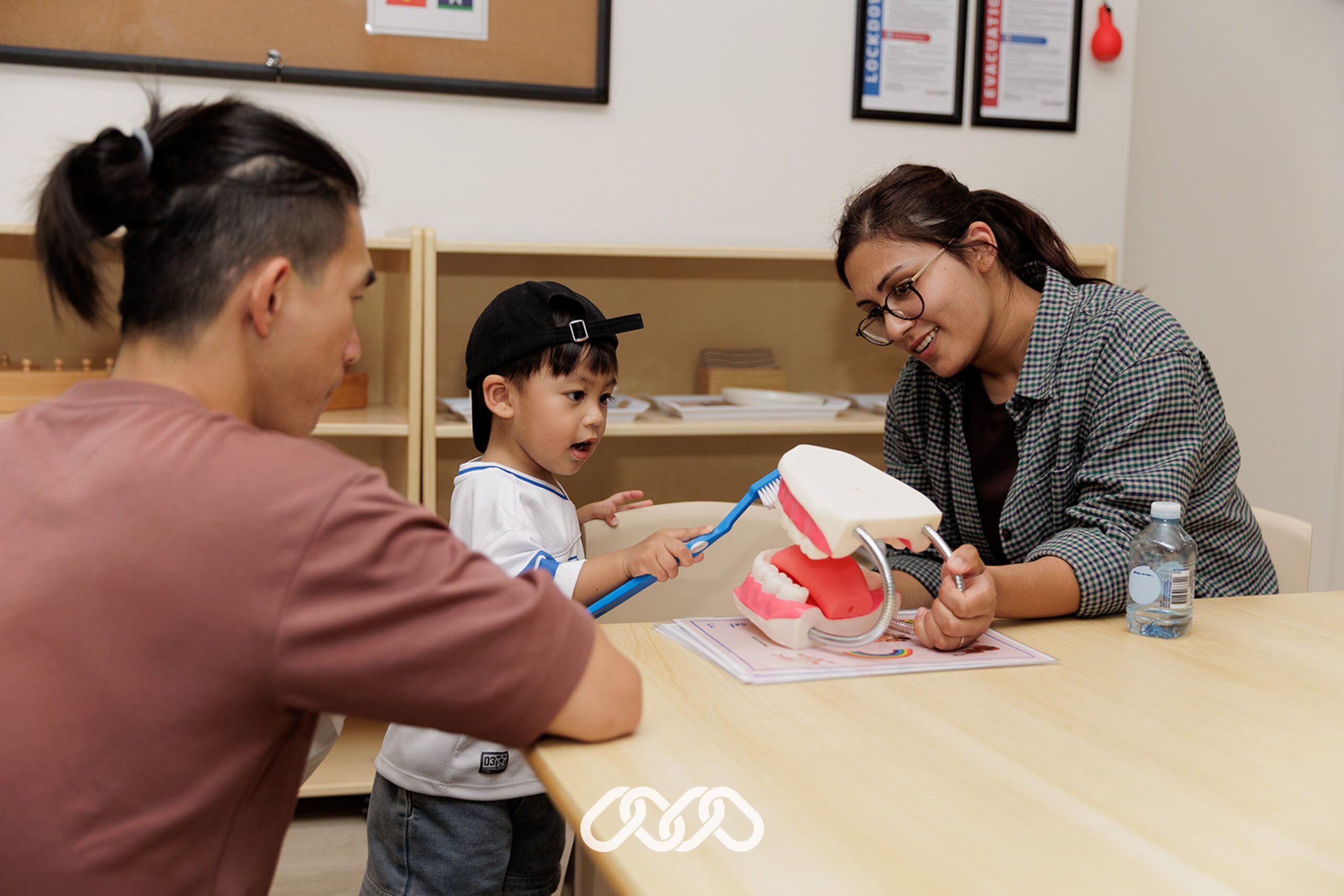 Child working with Montessori life like teeth for practical life teeth brushing task