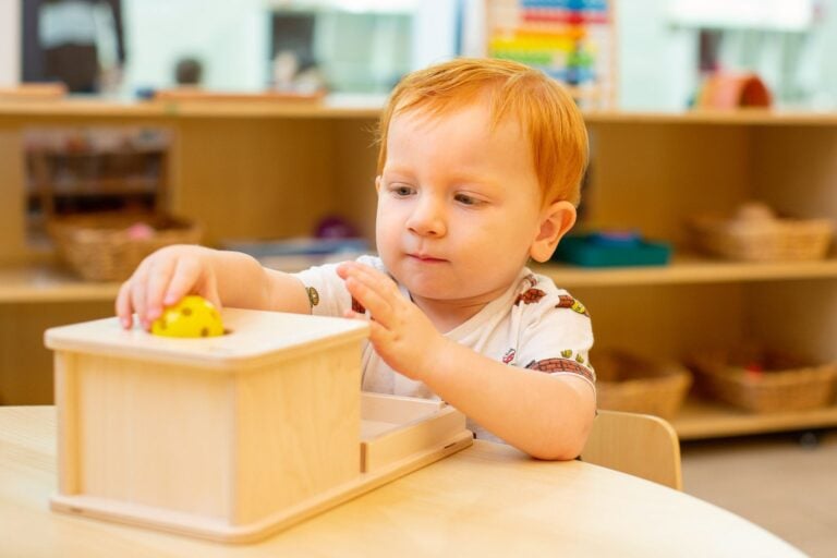 Toddler using hands-on Montessori learning material to support fine motor development