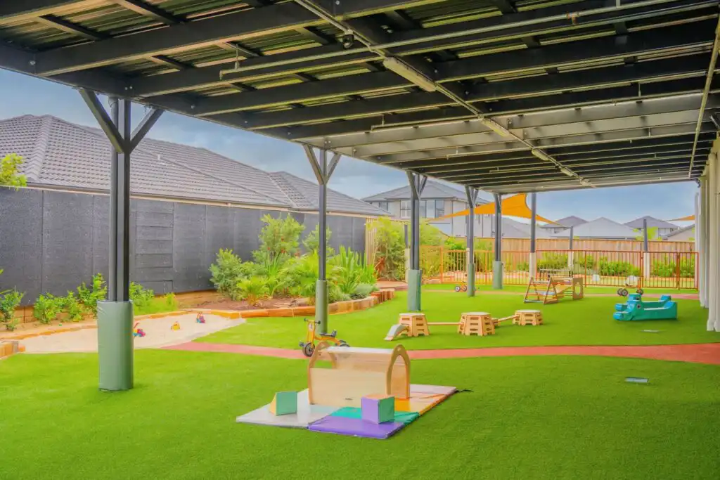 Covered outdoor play area at Leppington childcare centre with climbing equipment and open play space