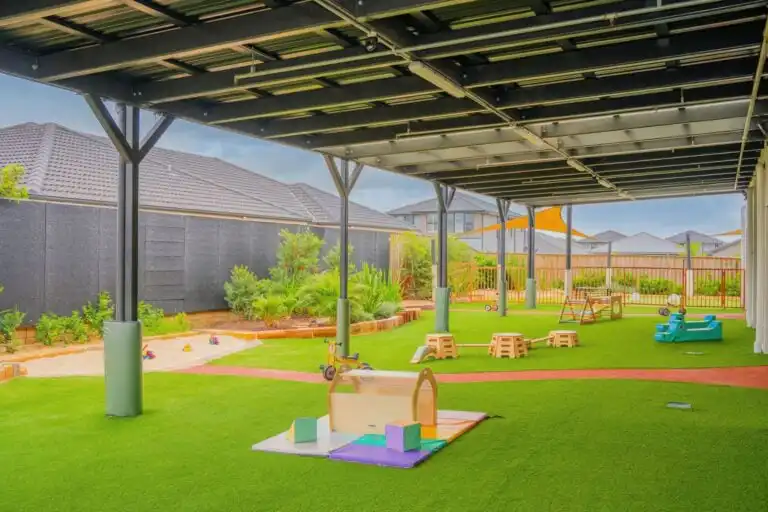 Covered outdoor play area at Leppington childcare centre with climbing equipment and open play space
