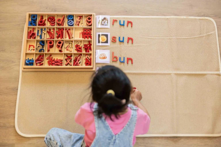 Child engaging with a Montessori language material on a wall.