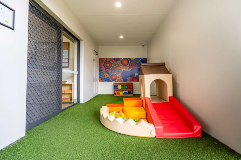 Indoor gross motor play area at Hurstville childcare centre with soft play equipment and slide