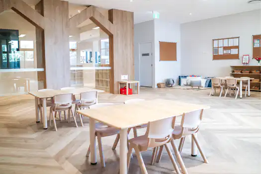 Toddler Montessori classroom at Lane Cove West Montessori Academy featuring natural timber furniture, open learning spaces, and child-sized tables for independent learning.