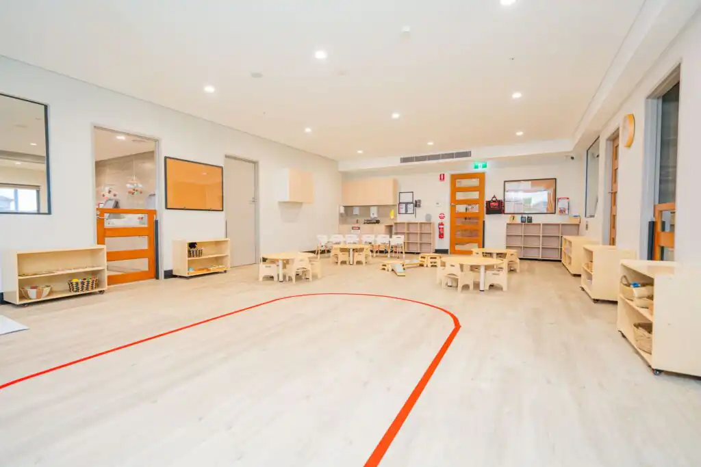 Spacious Montessori classroom at Leppington childcare centre with activity tables and learning shelves