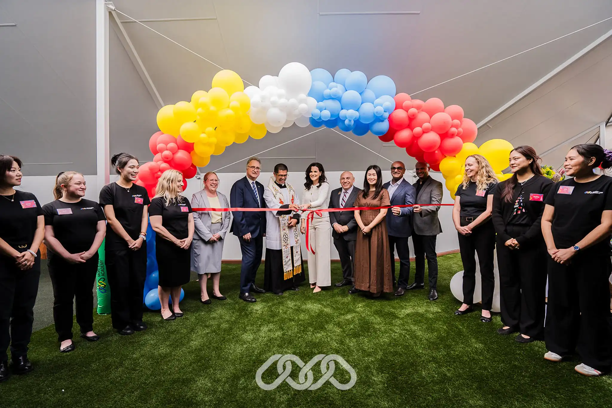Montessori Academy leadership and community leaders gather under colourful balloon arch