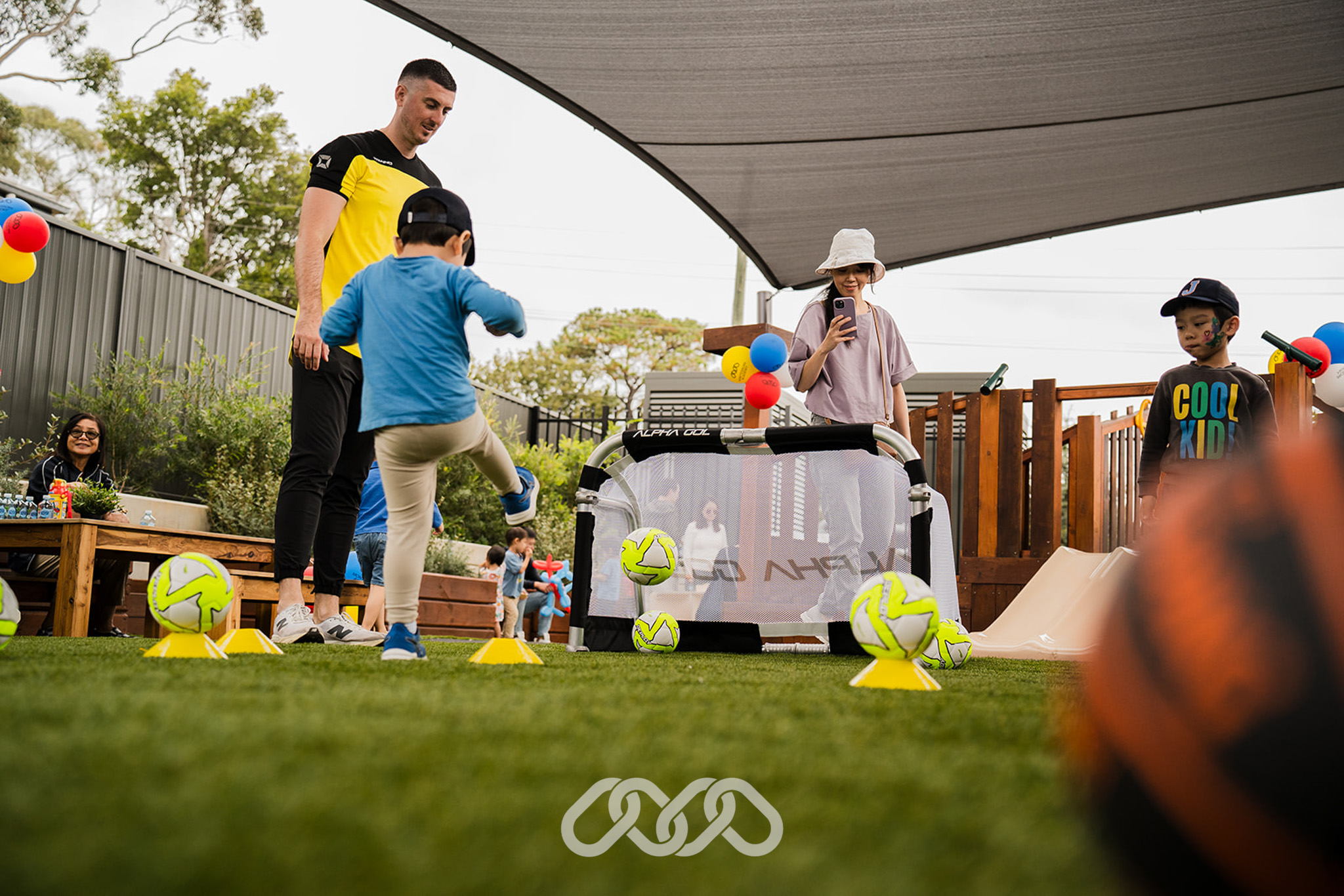 Child kicks child sized soccer ball into child sized soccer goal