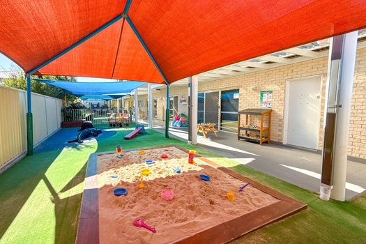 Shaded sandpit at Auburn Montessori Academy with outdoor sensory play space