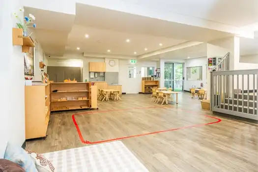Open Montessori classroom with wooden learning materials and play area at Balmain Road childcare centre