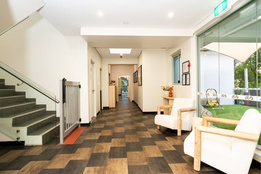 Childcare centre hallway and entrance area at Balmain Road Montessori Academy with seating and stair access