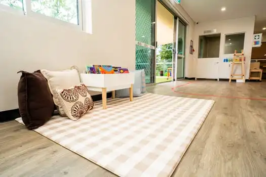 Cozy reading corner with books and cushions at Balmain Road Montessori childcare centre