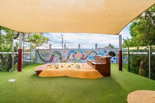 Montessori outdoor sandpit play area with shade and activity station at Balmain Road childcare centre