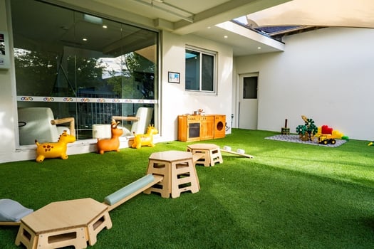 Montessori outdoor play area with balance equipment and toys at Balmain Road childcare centre