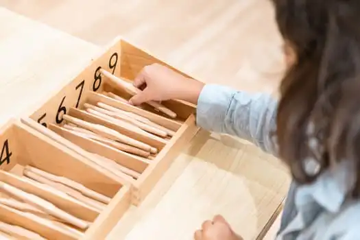 Child using Montessori spindle box mathematics material at Chatswood childcare