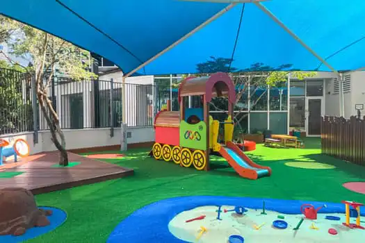 Outdoor playground at Chatswood childcare with train-themed play equipment