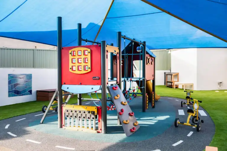 Montessori playground equipment at Mount Annan childcare with climbing wall, activity panels and shaded play area