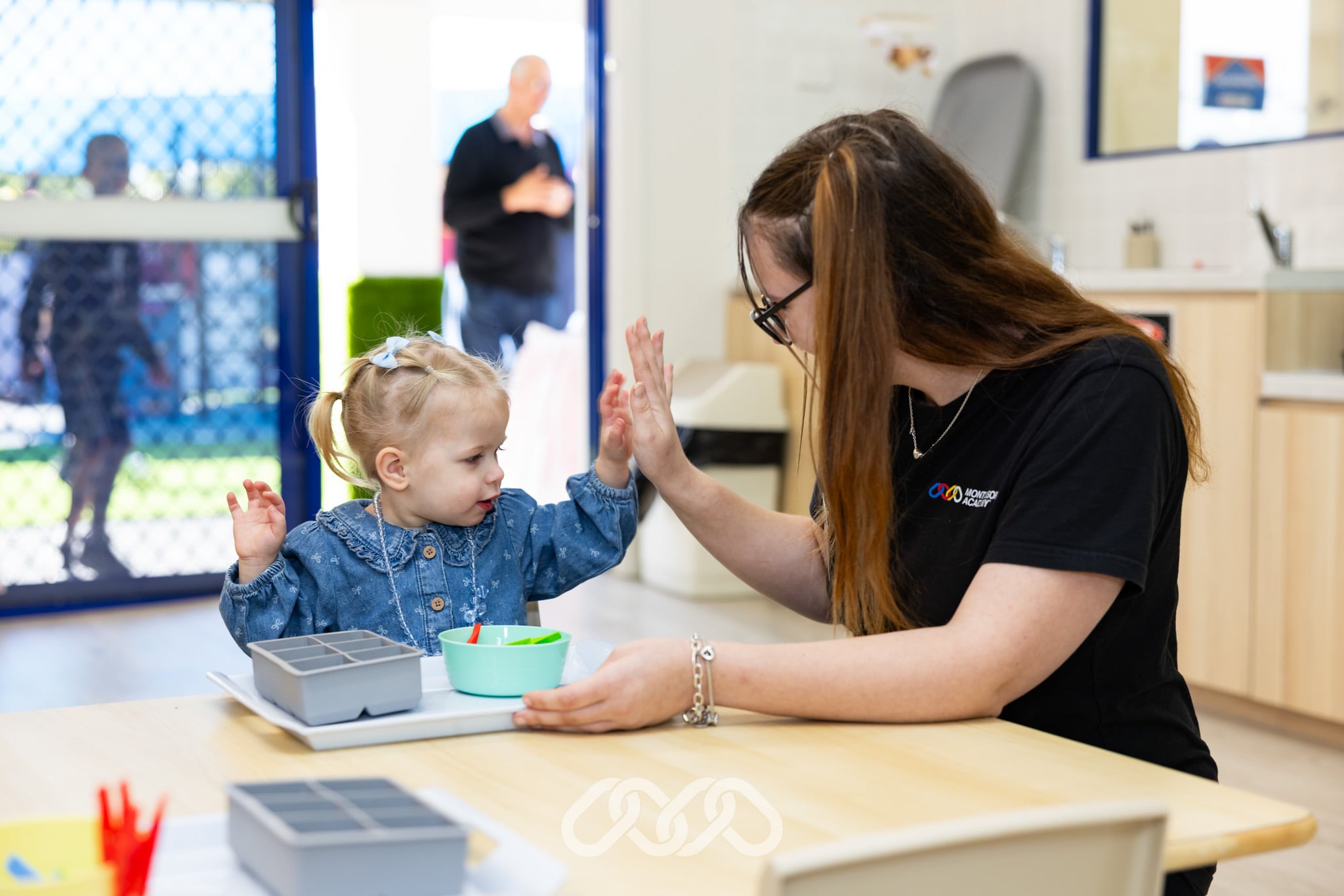 Child and educator participate in a Montessori learning activity at Mount Annan Montessori Academy's Grand Opening.