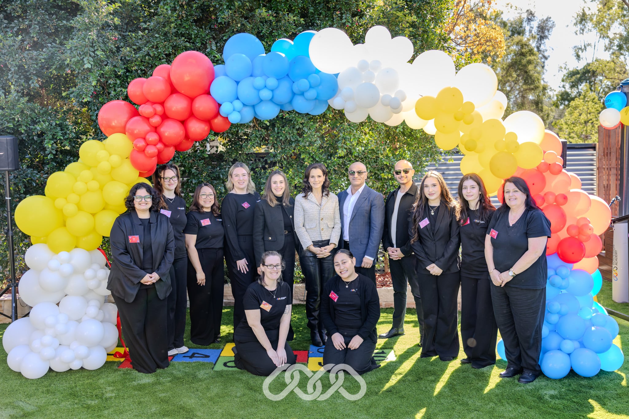 Educators, guests and community representatives at the Mount Annan Montessori Academy Grand Opening beneath a colourful balloon arch.