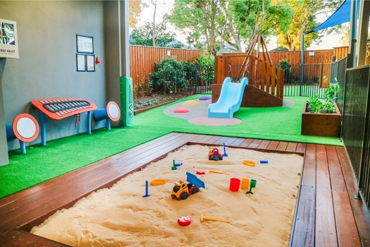 Outdoor sandpit at Revesby Montessori Academy with play materials and shaded learning space