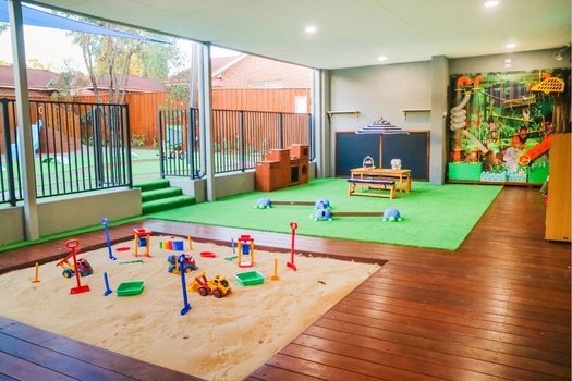 Covered sandpit play area at Revesby Montessori Academy with play materials and timber decking