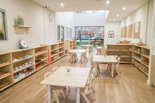 Montessori classroom at Revesby Montessori Academy with child-sized tables and learning shelves